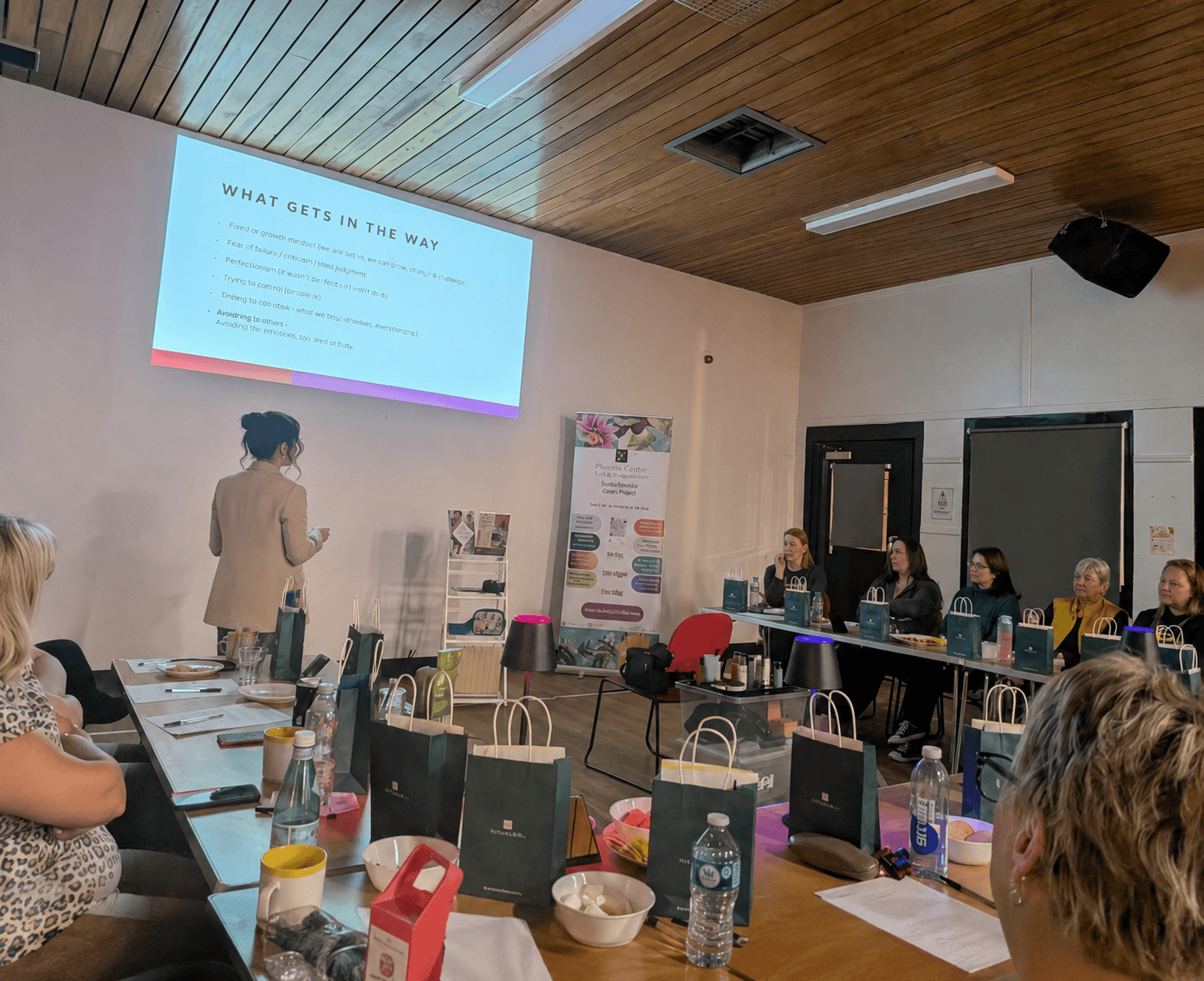 Women attending a workshop with a presenter and presentation screen.